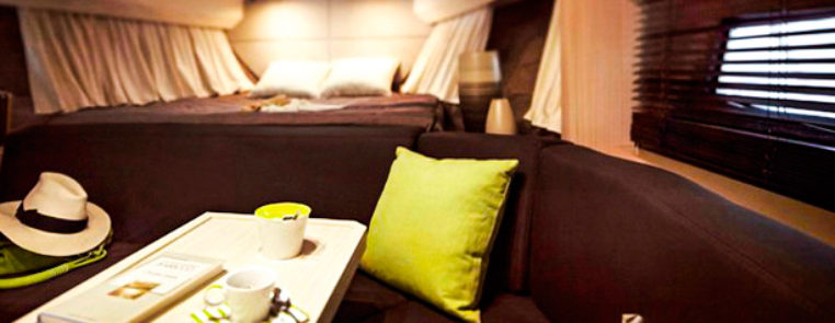 Sessa Marine C36 Magna Aqua: Cabine de Proa com sofá, mesa e cama ao fundo